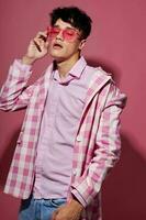 portrait de une Jeune homme dans rose des lunettes rose blazer posant studio isolé Contexte inchangé photo