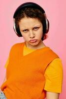 jolie fille dans un Orange chandail écouteurs la musique divertissement tondu vue inchangé photo