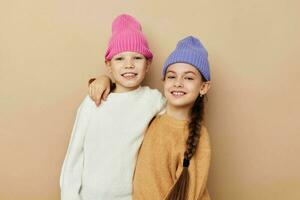 deux marrant peu les filles dans coloré Chapeaux posant photo