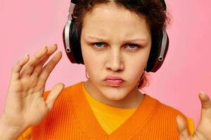 marrant fille dans un Orange veste écouteurs la musique divertissement mode de vie inchangé photo