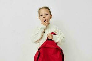 jolie Jeune fille école sac à dos avec une chapeau sur le sien tête enfance inchangé photo