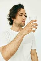 homme dans une blanc T-shirt verre de l'eau mode de vie inchangé photo