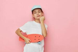 peu fille casquette dans blanc T-shirt planche à roulette isolé Contexte photo