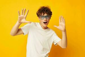 Jeune aux cheveux bouclés homme dans bleu des lunettes blanc T-shirt mode moderne style isolé Contexte inchangé photo