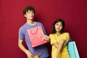 Jeune garçon et fille dans coloré t-shirts avec Sacs achats mode de vie inchangé photo