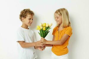 deux joyeux les enfants avec une bouquet de fleurs cadeau anniversaire vacances enfance lumière Contexte photo