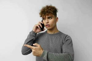 Beau Jeune homme avec une téléphone dans main la communication isolé Contexte photo