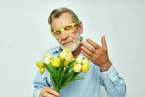 vieux homme une bouquet de fleurs avec des lunettes comme une cadeau lumière Contexte photo