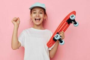 portrait de content souriant enfant fille avec une planche à roulette dans main isolé Contexte photo