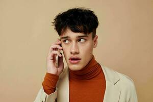 photo Jeune copain dans une beige veste parlant sur le téléphone mode de vie inchangé