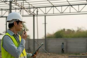 inspecteur ou ingénieur est inspecter construction et qualité assurance Nouveau maison en utilisant une tablette. ingénieurs ou architectes ou contacteur travail à construire le maison avant remise il plus de à le propriétaire photo