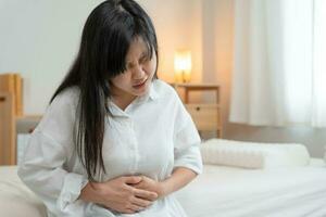 maux d'estomac. les femmes asiatiques ont des douleurs abdominales, une indigestion, une gastrite, des crampes menstruelles, des flatulences, de la diarrhée, une distension, un cancer du côlon, un problème d'inflammation du ventre, souffrent d'intoxication alimentaire, de l'abdomen photo