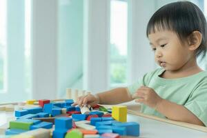 content Asie les enfants jouer et apprendre jouet blocs.famille est content et excité dans le maison. fille ayant amusement dépenses temps, activité, développement, iq, éq, méditation, cerveau, muscles, essentiel compétences. photo