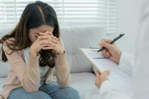 une femme ayant des problèmes de santé mentale consulte. le psychiatre enregistre l'état du patient pour le traitement. encouragement, problème d'amour et de famille, bipolaire, patient dépressif, protection contre le suicide photo