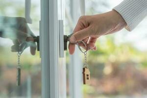 la clé du propriétaire pour déverrouiller la maison est branchée sur la porte. maison d'occasion à louer et à vendre. porte-clés souffle dans le vent. hypothèque pour maison neuve, acheter, vendre, rénover, investissement, propriétaire, immobilier photo