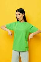 jolie brunette posant dans vert T-shirt émotions copie-espace Jaune Contexte inchangé photo
