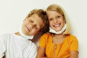 garçon et fille dans une médical masque amusement isolé Contexte inchangé photo