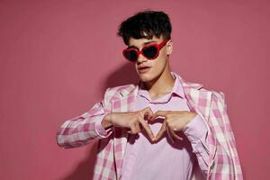 portrait de une Jeune homme des lunettes de soleil rose blazer mode élégant style isolé Contexte inchangé photo