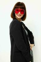 photo jolie femme dans rouge avec élégant des lunettes une cuir costume noir veste mode de vie inchangé