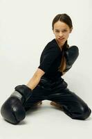 athlétique femme boxe noir gants posant des sports lumière Contexte photo
