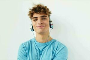 Beau gars dans bleu t-shirts écouteurs mode lumière Contexte photo