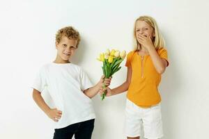 garçon et fille avec une bouquet de fleurs cadeau anniversaire vacances enfance lumière Contexte photo