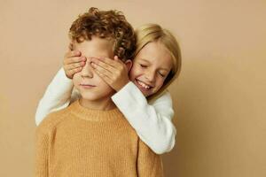 mignonne élégant les enfants étreinte divertissement posant relation amicale beige Contexte photo