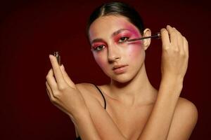 portrait de magnifique Jeune femme maquillage émotions produits de beauté cheveux se soucier mascara rose Contexte inchangé photo