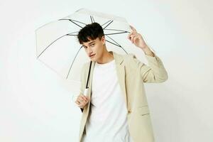 photo Jeune copain en portant un parapluie dans le mains de posant mode lumière Contexte inchangé