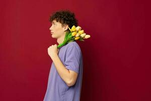 adolescent en portant une Jaune bouquet de fleurs violet t-shirts rouge Contexte inchangé photo