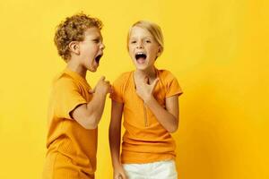 portrait de mignonne les enfants câlins mode enfance divertissement Jaune Contexte inchangé photo