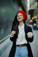 mode femme sourire avec les dents portrait en marchant touristique dans élégant vêtements dans veste avec rouge lèvres en marchant vers le bas étroit ville rue en volant cheveux, voyage, cinématique couleur, rétro ancien style. photo