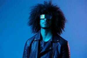 portrait de mode homme avec frisé cheveux avec élégant des lunettes sur bleu Contexte multinational, coloré lumière, noir cuir veste s'orienter, moderne concept. photo