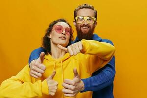 homme et femme couple souriant gaiement et courbé avec lunettes, sur Jaune arrière-plan, symboles panneaux et main gestes, famille tirer, jeunes mariés. photo