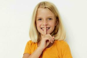 de bonne humeur fille dans une Jaune T-shirt posant lumière Contexte photo