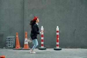 mode femme fonctionnement vers le bas le rue dans de face de le ville touristique dans élégant vêtements avec rouge lèvres et rouge béret, voyage, cinématique couleur, rétro ancien style. photo