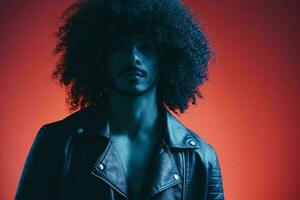 portrait de mode homme avec frisé cheveux sur rouge Contexte multinational, coloré lumière, noir cuir veste s'orienter, moderne concept. photo