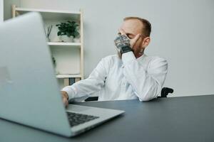 une homme fauteuil roulant, une homme d'affaire dans un Bureau à une ordinateur portable, fatigue et émotif Burnout à le fin de le travail jour, le concept de travail une la personne avec handicapées, liberté de social cadres photo