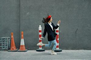 mode femme fonctionnement vers le bas le rue dans de face de le ville touristique dans élégant vêtements avec rouge lèvres et rouge béret, voyage, cinématique couleur, rétro ancien style, en retard à travail. photo