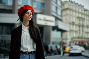 une sourire femme avec affaires les dents des promenades dans le ville contre le toile de fond de Bureau bâtiments, élégant à la mode vêtements et se maquiller, printemps marcher, Voyage. photo