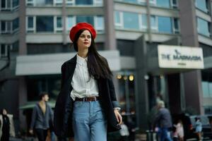 une affaires femme des promenades dans le ville contre le toile de fond de Bureau bâtiments, élégant à la mode vêtements et se maquiller, printemps marcher, Voyage. photo