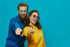 une femme et une homme amusement couple lancer et montrant panneaux avec leur mains souriant gaiement, sur une bleu arrière-plan, le concept de une réel relation dans une famille. photo