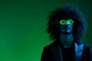 mode portrait de une homme avec frisé cheveux sur une vert Contexte avec des lunettes de soleil, multinational, coloré rose lumière, branché, moderne concept. photo