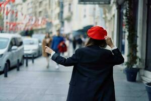 femme bonheur vue de le dos, suivre moi des promenades des promenades dans le ville contre le toile de fond de Bureau bâtiments, élégant à la mode ancien vêtements et se maquiller, printemps marcher, Voyage. photo