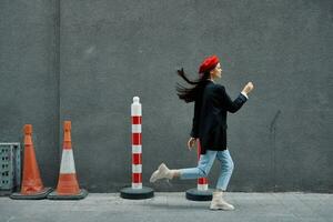 mode femme fonctionnement vers le bas le rue dans de face de le ville touristique dans élégant vêtements avec rouge lèvres et rouge béret, voyage, cinématique couleur, rétro ancien style, en retard à travail, courir. photo