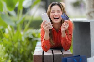 portrait en plein air de femme heureuse tenant une carte de crédit