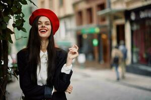 fille sourire avec les dents des stands sur le rue dans le ville dans une veste et rouge béret, cinématique français mode style vêtements, Voyage à Istanbul photo