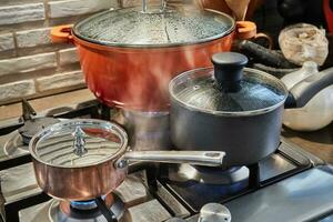 casseroles avec cuisson des aliments dans la cuisine sur cuisinière à gaz photo