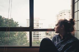 femme inquiète à la recherche de la fenêtre de son appartement photo