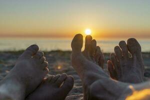 pieds de le père et enfant dans le le sable sur le plage photo